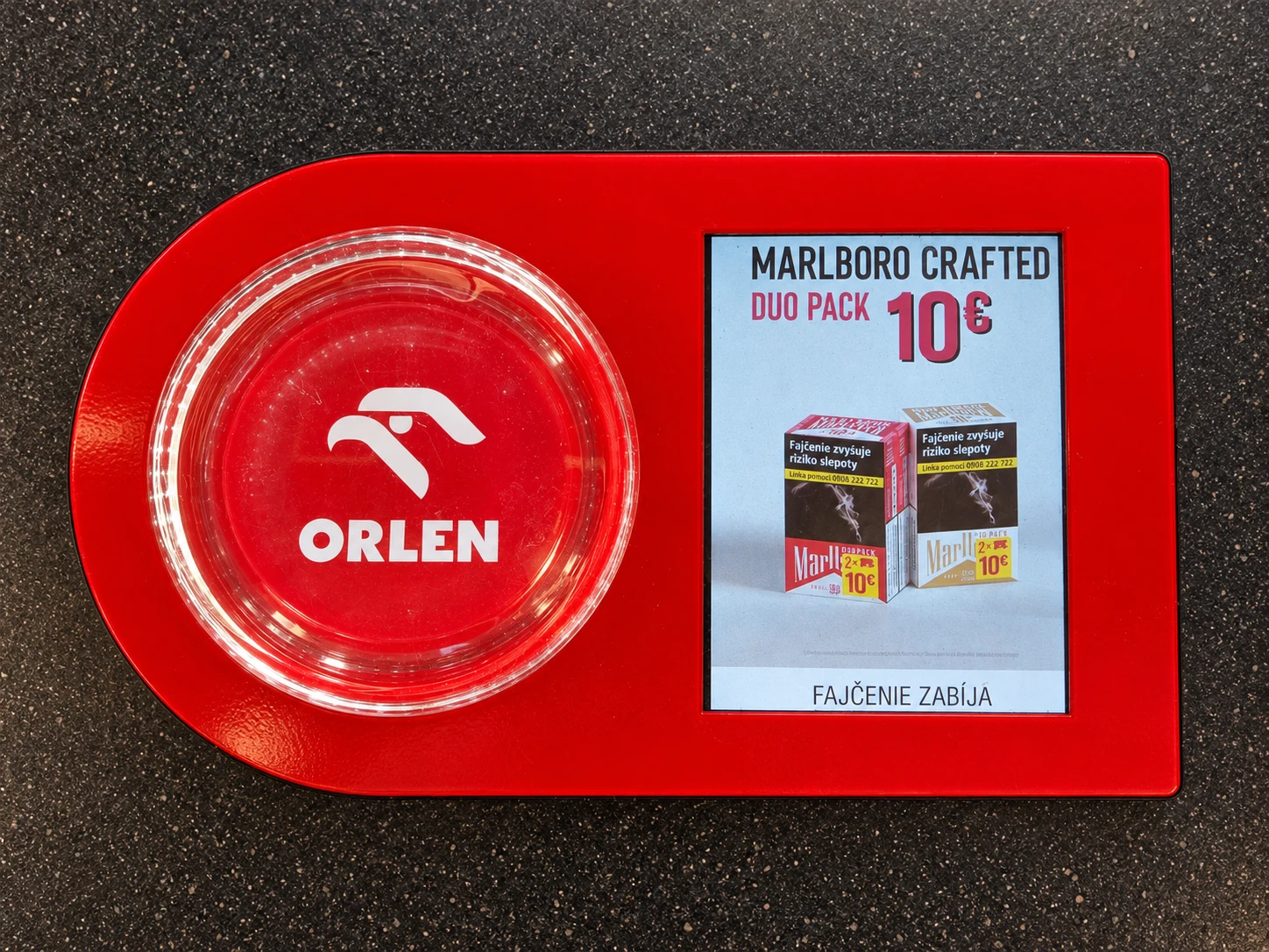 Digitální mincovník ORLEN s miskou na mince a malou obrazovkou.